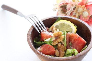 Tomato and walnut salad on white background with copy space