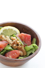 Tomato and walnut salad on white background with copy space