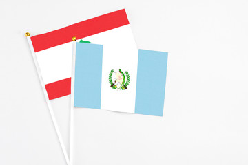 Guatemala and Lebanon stick flags on white background. High quality fabric, miniature national flag. Peaceful global concept.White floor for copy space.