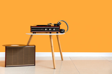 Record player on table near color wall