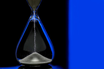 Crystal hourglass on dark background, closeup