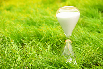 Crystal hourglass on grass outdoors