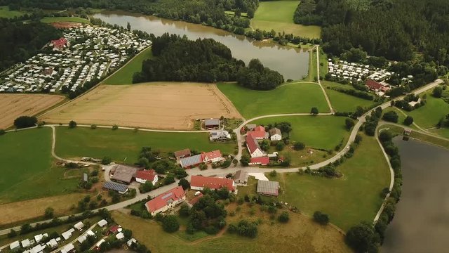 Aerial pan shot of Haselbach reservoir lake with camp site