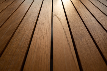 Real wood floor laid in the same level with equal spaces in every piece and have some of the sunset rays enter the image. Giving a warm feeling, hope, love, care and suitable for making to background