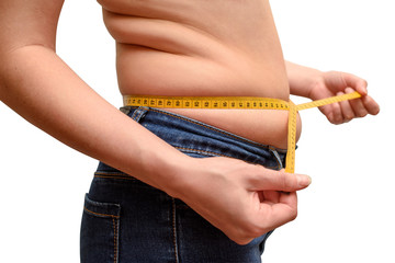 Close up of young overweight woman measuring her waist with tape measure isolated on white...