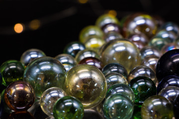 Glass balls on a black glass table. In the background is yellow bokeh.