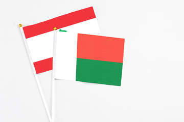 Madagascar and Lebanon stick flags on white background. High quality fabric, miniature national flag. Peaceful global concept.White floor for copy space.