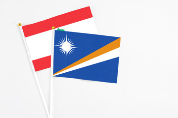 Marshall Islands and Lebanon stick flags on white background. High quality fabric, miniature national flag. Peaceful global concept.White floor for copy space.