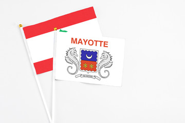 Mayotte and Lebanon stick flags on white background. High quality fabric, miniature national flag. Peaceful global concept.White floor for copy space.
