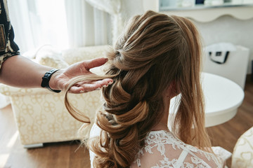 Hairdresser making hairstyle for woman, copy space. Bride morning. Wedding hairstyle on long hair,...