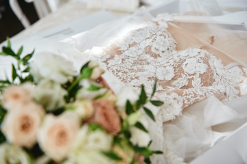 Beautiful luxury wedding dress in white box on bed, copy space. Bridal morning preparations. Wedding concept