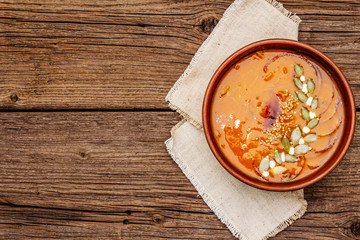 Autumn pumpkin cream soup. Traditional ingredients, healthy food concept. Napkin, vintage wooden background