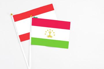 Tajikistan and Lebanon stick flags on white background. High quality fabric, miniature national flag. Peaceful global concept.White floor for copy space.