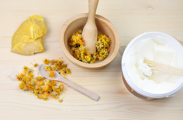 Medical herbs concept with dry cannabis, verbascum and calendula on a wooden background. Production of homemade ointment.