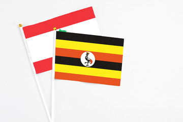 Uganda and Lebanon stick flags on white background. High quality fabric, miniature national flag. Peaceful global concept.White floor for copy space.