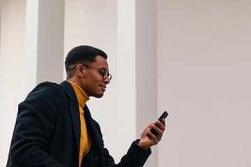 junger Mann schaut auf das Mobiltelefon nach einer SMS Nachricht