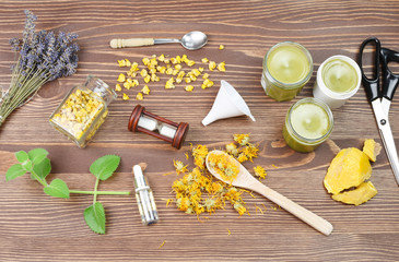 Medical herbs concept with dry cannabis, verbascum and calendula on a wooden background. Production of homemade ointment.