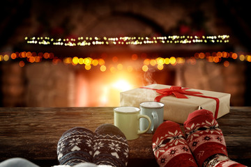 Blurred background of chrsitmas fireplace.Orange color of warm light of fire.Woman legs with socks and jeans.Copy space.Free place for your decoration.Cold winter december night.Christmas Eve party.