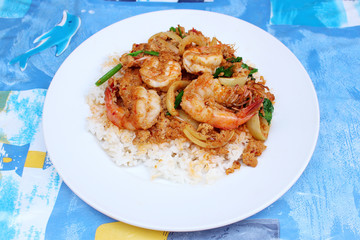 Rice with stir fried shrimps in yellow curry powder on top,Thai food