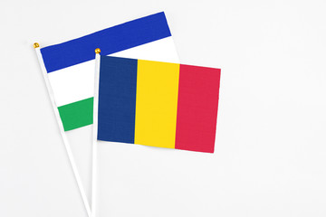 Chad and Lesotho stick flags on white background. High quality fabric, miniature national flag. Peaceful global concept.White floor for copy space.