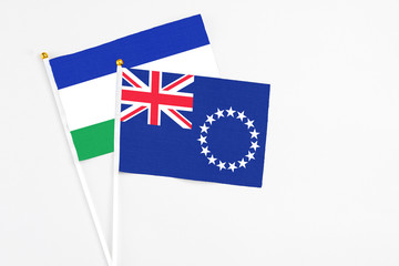 Cook Islands and Lesotho stick flags on white background. High quality fabric, miniature national...
