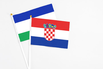 Croatia and Lesotho stick flags on white background. High quality fabric, miniature national flag....