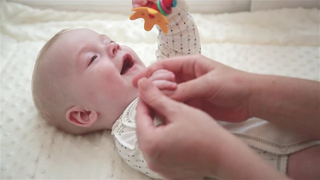 A mother gives her son a developmental hand massage at home. Medicine and healthcare. The concept of family happiness. Close up