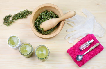 Medical herbs concept with dry cannabis, verbascum and calendula on a wooden background. Production of homemade ointment.