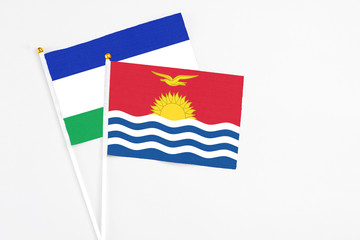 Kiribati and Lesotho stick flags on white background. High quality fabric, miniature national flag. Peaceful global concept.White floor for copy space.