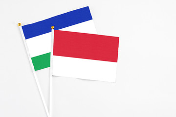 Monaco and Lesotho stick flags on white background. High quality fabric, miniature national flag. Peaceful global concept.White floor for copy space.