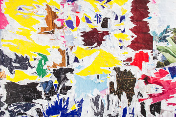 Old dirty ripped and peeling paper posters with traces of glue on street billboard texture...
