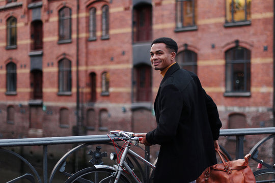 junger Mann schiebt sein Fahrad in der Speicherstadt Hamburg