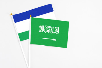 Saudi Arabia and Lesotho stick flags on white background. High quality fabric, miniature national...
