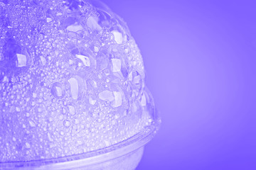Oxygen cocktail foam in a plastic glass on a bright pink background with a sprig of mint