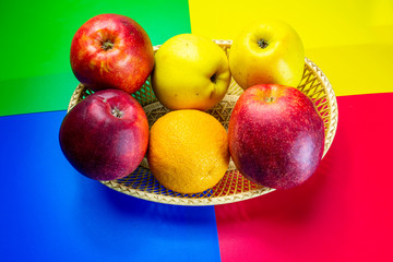 fresh fruits, red and green apples and oranges in a green basket