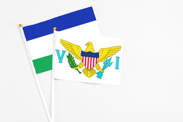 United States Virgin Islands and Lesotho stick flags on white background. High quality fabric,...
