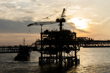 Silhouette of oil production platform during sunset at oil field