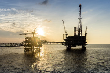 Silhouette of oil production platform during sunset at oil field