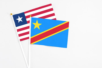 Congo and Liberia stick flags on white background. High quality fabric, miniature national flag. Peaceful global concept.White floor for copy space.