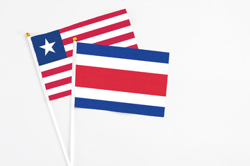 Costa Rica and Liberia stick flags on white background. High quality fabric, miniature national flag. Peaceful global concept.White floor for copy space.