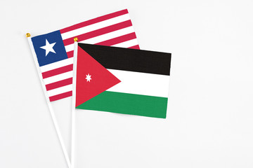 Jordan and Liberia stick flags on white background. High quality fabric, miniature national flag. Peaceful global concept.White floor for copy space.
