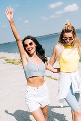 cheerful girls walking near river in summer