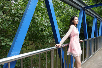 Portrait of young asian woman standing on a bridge