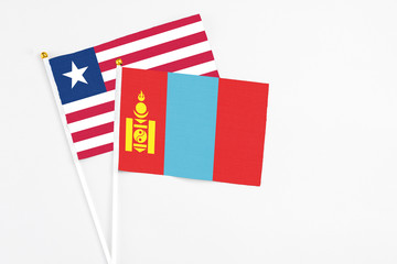 Mongolia and Liberia stick flags on white background. High quality fabric, miniature national flag. Peaceful global concept.White floor for copy space.