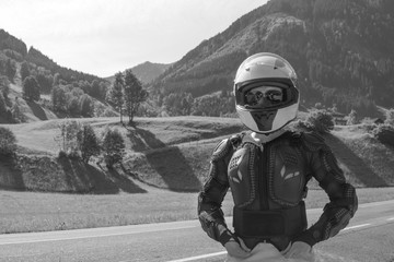 Black and white Close up portrait of a girl in full body protection, turtle armor, knee pads and helmet, on a background of green mountains, summer sunny day, rady to ride for adventure. copy space - obrazy, fototapety, plakaty