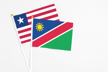 Namibia and Liberia stick flags on white background. High quality fabric, miniature national flag. Peaceful global concept.White floor for copy space.