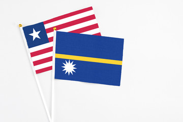 Nauru and Liberia stick flags on white background. High quality fabric, miniature national flag. Peaceful global concept.White floor for copy space.