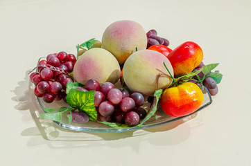 Home still life with fruits, flowers and kitchenware. Home decoration, still life in the apartment. Fruit still life on the background of the interior