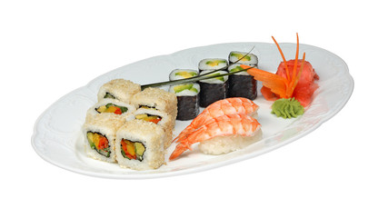 Sushi with shrimps and rolls with cucumber, avocado, paprika and nori. Pickled ginger and wasabi on white oval plate