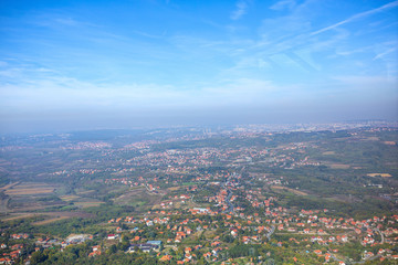 panorama of city downtown houses and church aerial view above the roofs with sun in summer